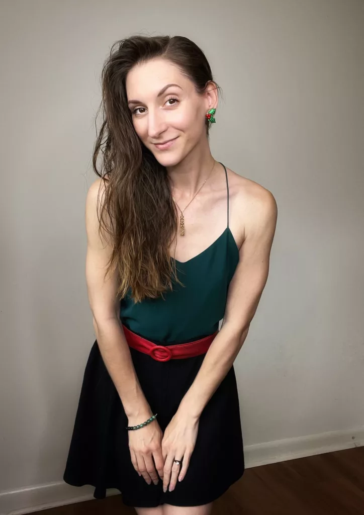 Bri shows off her Christmas in July outfit using holiday earrings, and a Christmas color palette with a red belt, and green sleeveless blouse for her summer look